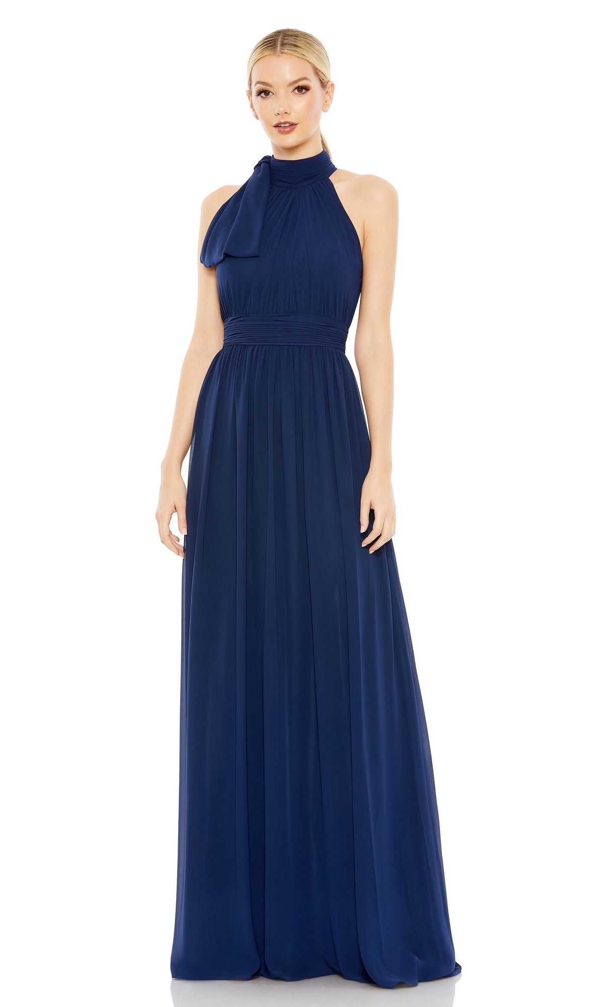 Woman wearing the Mac Duggal 55035 High-Neck Long Formal Dress—a sleeveless, floor-length navy gown with shoulder bow detail—standing against a white backdrop.